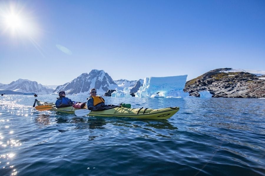 Kayak between icebergs